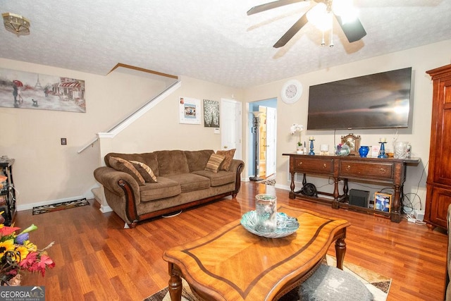 1346 Revelstoke Cv, Riverdale, GA 30296 - living area with wood finished floors, a textured ceiling, a ceiling fan, stairs, and baseboards