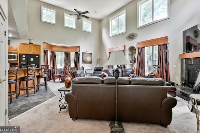 226 Long Island Dr, Whitesburg, GA 30185 - living room featuring a high ceiling, a ceiling fan, light colored carpet, healthy amount of natural light, and a tile fireplace