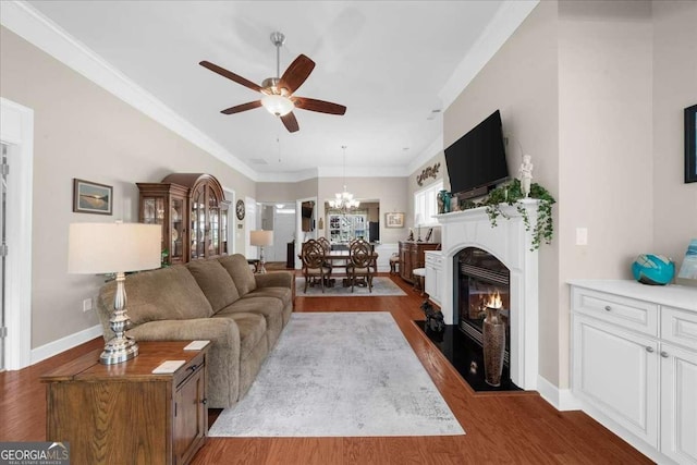3554 Black Cherry Pt SW, Gainesville, GA 30504 - living room featuring dark wood-style flooring, a ceiling fan, a chandelier, baseboards, and ornamental molding