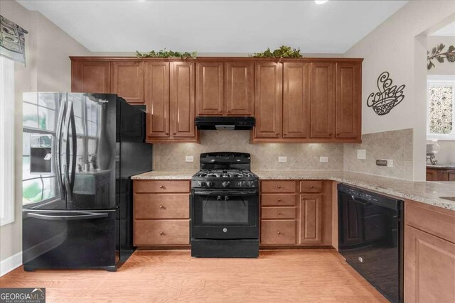 3554 Black Cherry Pt SW, Gainesville, GA 30504 - kitchen featuring black appliances, under cabinet range hood, lofted ceiling, light wood-style flooring, and brown cabinets