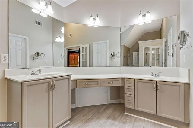 2073 Woodside Park Dr, Woodstock, GA 30188 - bathroom featuring two vanities, high vaulted ceiling, and wood finished floors