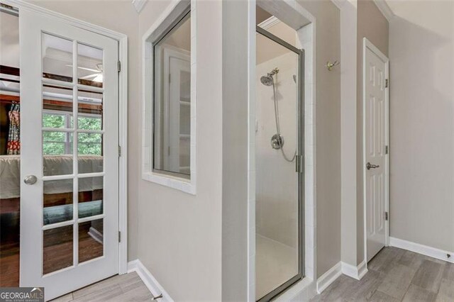 2073 Woodside Park Dr, Woodstock, GA 30188 - bathroom with a stall shower, wood finished floors, and baseboards