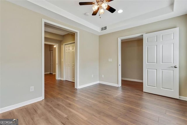 2073 Woodside Park Dr, Woodstock, GA 30188 - unfurnished bedroom with a raised ceiling, wood finished floors, and baseboards