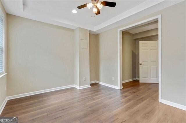 2073 Woodside Park Dr, Woodstock, GA 30188 - unfurnished room with ceiling fan, wood finished floors, recessed lighting, a tray ceiling, and baseboards