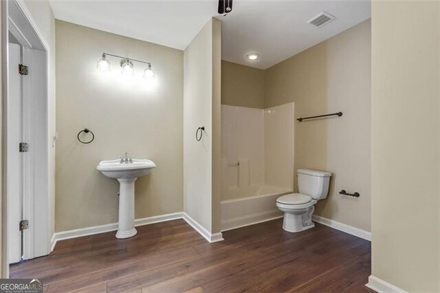 2073 Woodside Park Dr, Woodstock, GA 30188 - full bathroom with toilet, wood finished floors, baseboards, and bathtub / shower combination