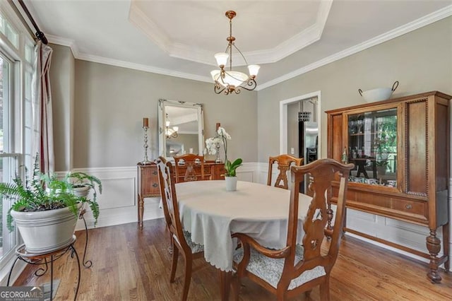 2073 Woodside Park Dr, Woodstock, GA 30188 - dining room featuring healthy amount of natural light, a chandelier, wood finished floors, a wainscoted wall, and a raised ceiling