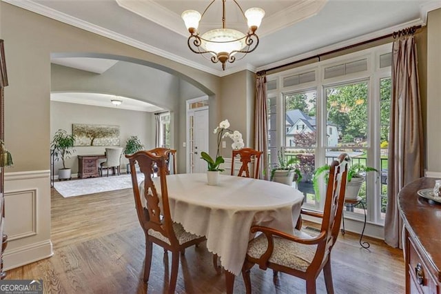 2073 Woodside Park Dr, Woodstock, GA 30188 - dining room featuring arched walkways, plenty of natural light, a chandelier, light wood-style flooring, and ornamental molding