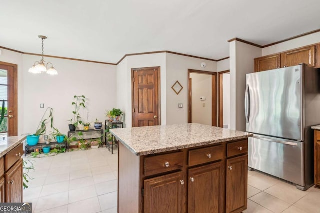 6165 Pin Oak Ln, Alpharetta, GA 30005 - kitchen featuring freestanding refrigerator, light tile patterned floors, crown molding, pendant lighting, and a chandelier