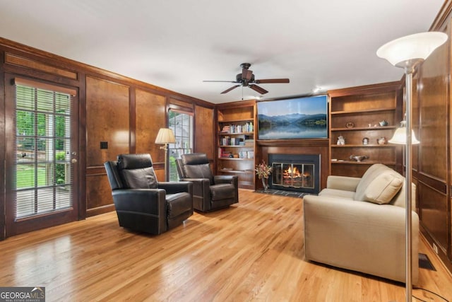 6165 Pin Oak Ln, Alpharetta, GA 30005 - living room with light wood-style floors, a fireplace with flush hearth, a ceiling fan, and wooden walls