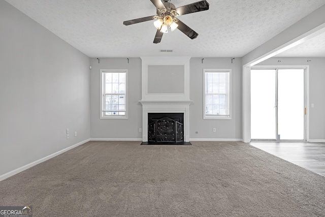145 Silver Mine Trl, Austell, GA 30168 - unfurnished living room featuring a textured ceiling, a fireplace with flush hearth, ceiling fan, baseboards, and carpet