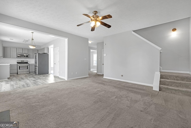 145 Silver Mine Trl, Austell, GA 30168 - unfurnished living room with ceiling fan, baseboards, stairs, and light colored carpet
