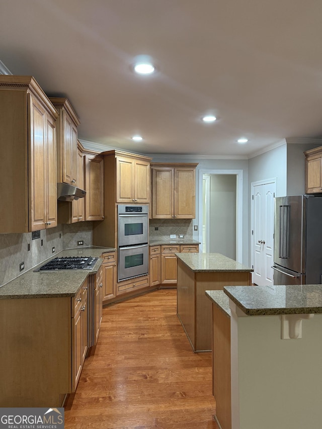 2360 Barrington Trace Cir SW, South Fulton, GA 30331 - kitchen with stainless steel appliances, crown molding, under cabinet range hood, a center island, and light wood finished floors