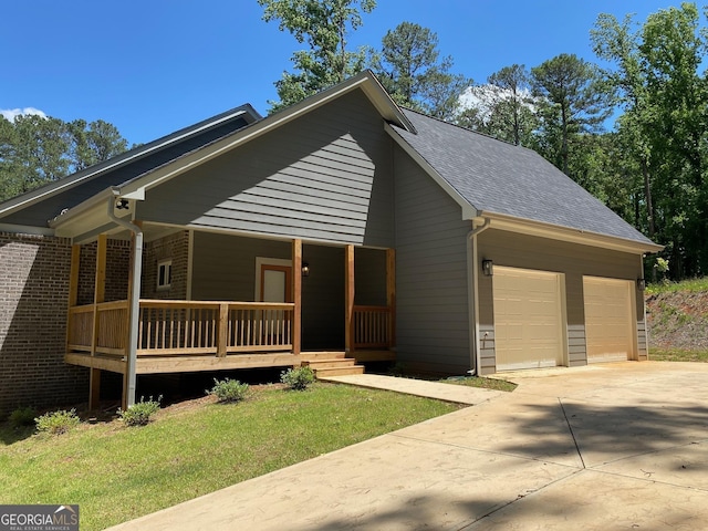 5950 Lynfield Dr, South Fulton, GA 30349 - view of front of house featuring a garage, covered porch, driveway, a front lawn, and a shingled roof
