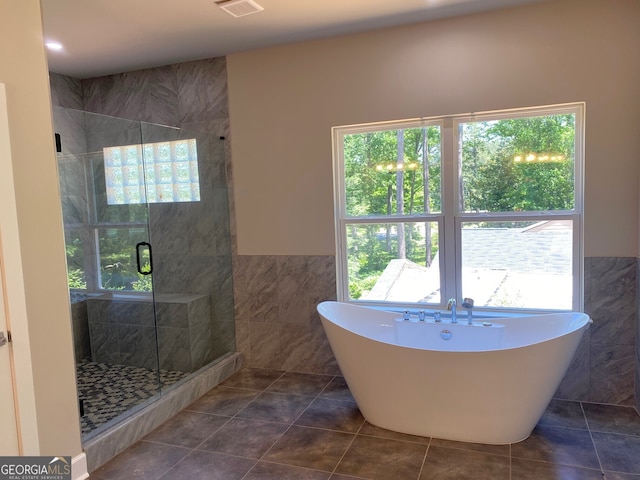 5950 Lynfield Dr, South Fulton, GA 30349 - full bath with tile walls, plenty of natural light, a freestanding tub, a shower stall, and wainscoting