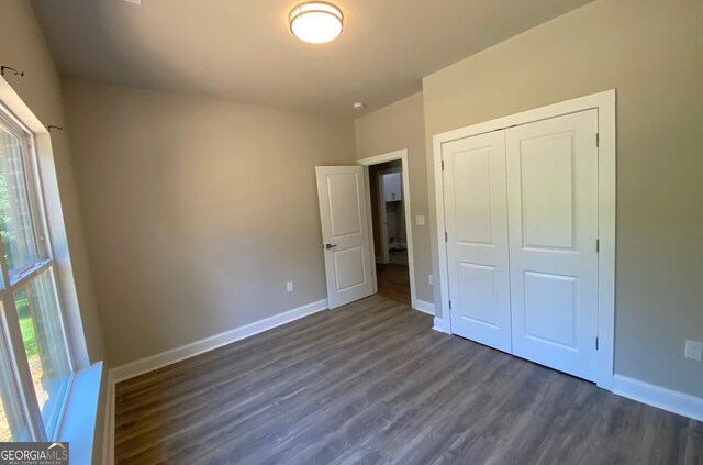5950 Lynfield Dr, South Fulton, GA 30349 - unfurnished bedroom featuring dark wood finished floors, baseboards, and a closet