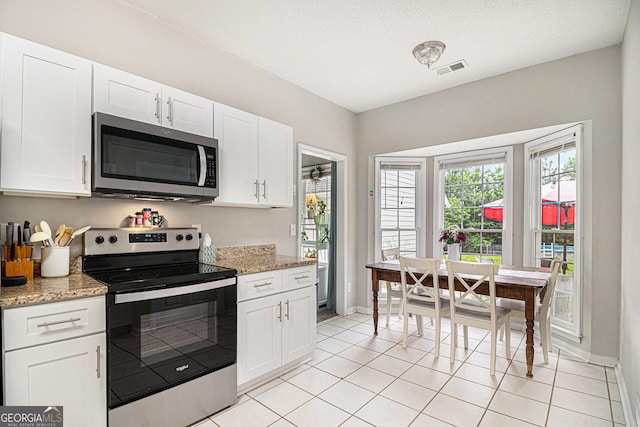 385 Eagles Nest Cir, Carrollton, GA 30116 - kitchen featuring stainless steel appliances, white cabinets, baseboards, and light tile patterned flooring