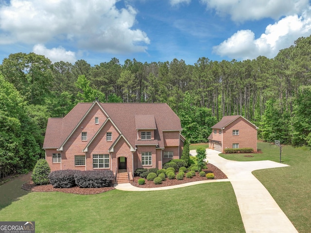 210 Short Rd, Sharpsburg, GA 30277 - view of front of home featuring a forest view, a front yard, brick siding, an outbuilding, and a detached garage