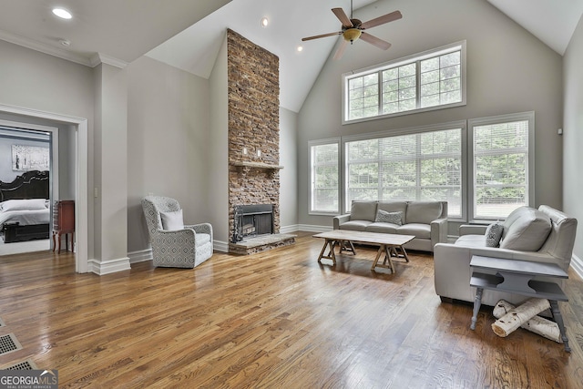 210 Short Rd, Sharpsburg, GA 30277 - living room featuring high vaulted ceiling, a ceiling fan, a stone fireplace, hardwood / wood-style flooring, and baseboards