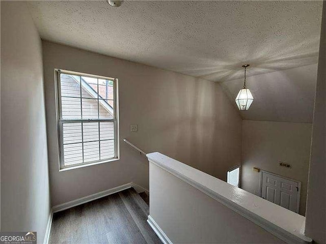 1720 New Orleans Way, Mcdonough, GA 30252 - corridor with an upstairs landing, dark wood finished floors, baseboards, a textured ceiling, and vaulted ceiling
