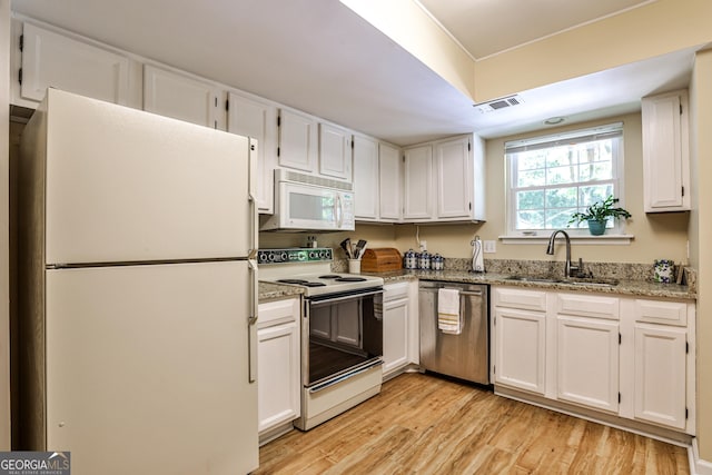 1750 Clairmont Rd Unit 35, Decatur, GA 30033 - kitchen featuring white appliances, a sink, light wood-style flooring, and white cabinets