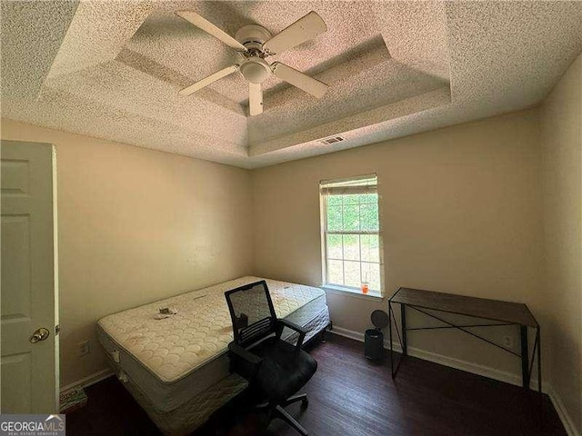 160 Goldleaf Dr, Hampton, GA 30228 - bedroom featuring a textured ceiling, dark wood-type flooring, a raised ceiling, a ceiling fan, and baseboards