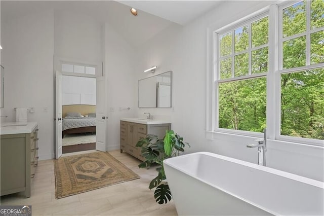 4356 N Buckhead Dr NE, Atlanta, GA 30342 - bathroom featuring healthy amount of natural light, two vanities, a freestanding bath, and high vaulted ceiling
