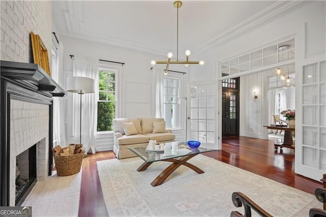 4356 N Buckhead Dr NE, Atlanta, GA 30342 - living room featuring wood finished floors, crown molding, a decorative wall, a fireplace, and a chandelier