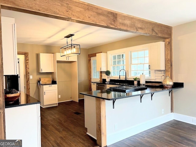 125 Oak Ave, Carrollton, GA 30117 - kitchen with a peninsula, dark wood finished floors, dark countertops, appliances with stainless steel finishes, and a sink