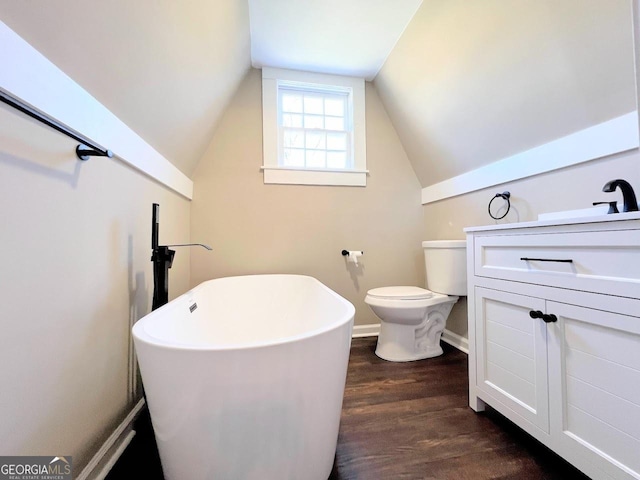 125 Oak Ave, Carrollton, GA 30117 - bathroom with a freestanding bath, wood finished floors, lofted ceiling, toilet, and vanity