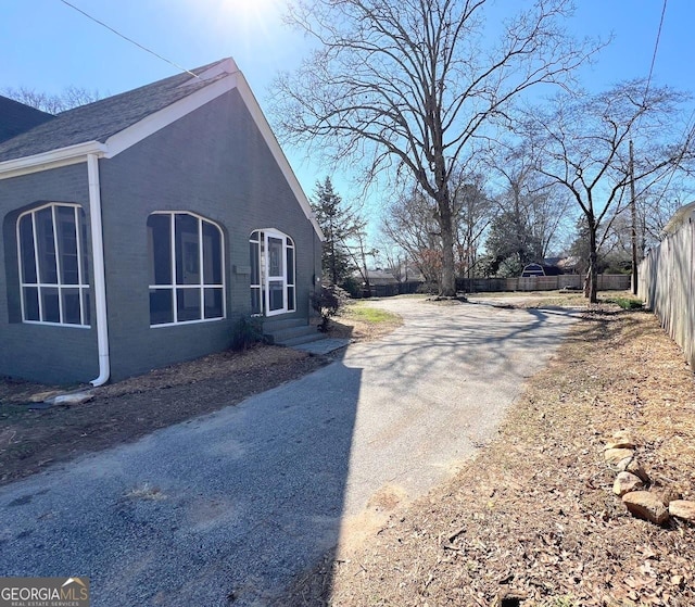 125 Oak Ave, Carrollton, GA 30117 - view of side of home featuring asphalt driveway, brick siding, and entry steps