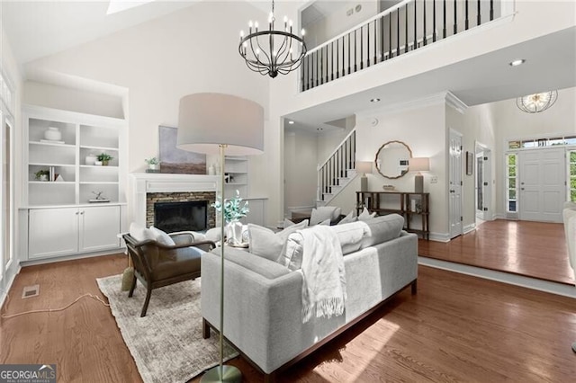 3600 Goldenrod Dr, Alpharetta, GA 30005 - living room with a chandelier, a high ceiling, wood finished floors, built in shelves, and stairs