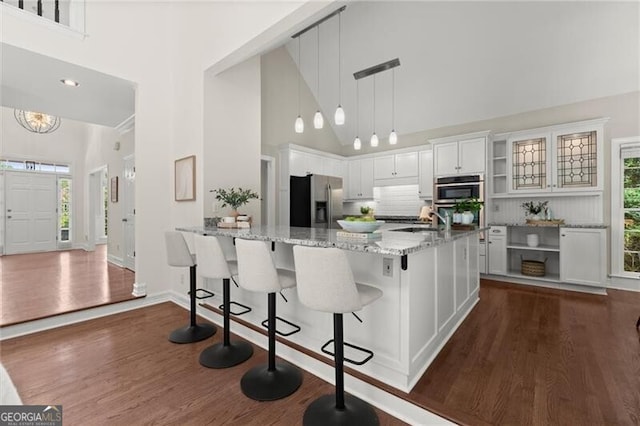 3600 Goldenrod Dr, Alpharetta, GA 30005 - kitchen with stainless steel appliances, a high ceiling, dark wood-style floors, light stone countertops, and white cabinetry