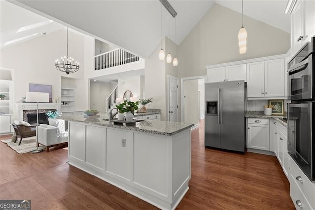 3600 Goldenrod Dr, Alpharetta, GA 30005 - kitchen featuring stainless steel fridge, high vaulted ceiling, light stone counters, white cabinets, and open floor plan