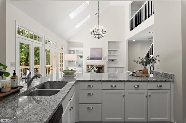 3600 Goldenrod Dr, Alpharetta, GA 30005 - kitchen featuring a sink, a skylight, high vaulted ceiling, a chandelier, and built in shelves
