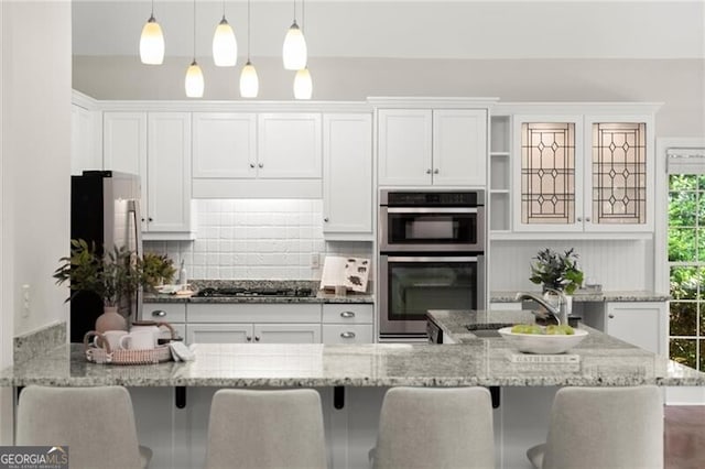 3600 Goldenrod Dr, Alpharetta, GA 30005 - kitchen featuring stainless steel appliances, white cabinets, a kitchen bar, and pendant lighting