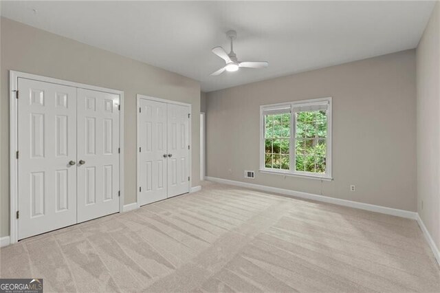 3600 Goldenrod Dr, Alpharetta, GA 30005 - unfurnished bedroom featuring multiple closets, light colored carpet, and ceiling fan