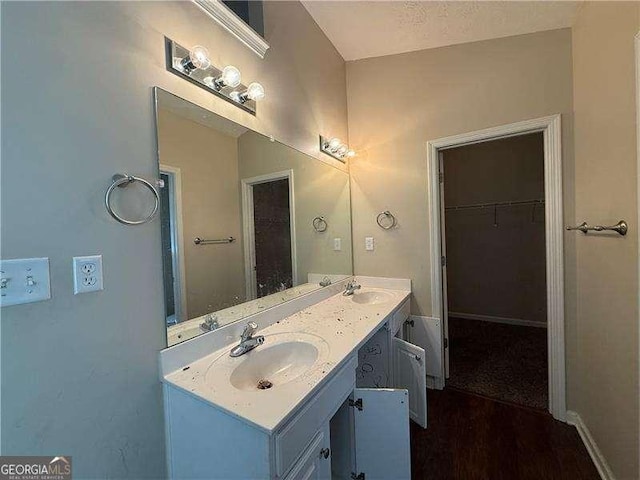 124 Sparkling Spring Trl, Mcdonough, GA 30252 - full bathroom with double vanity, a spacious closet, and wood finished floors