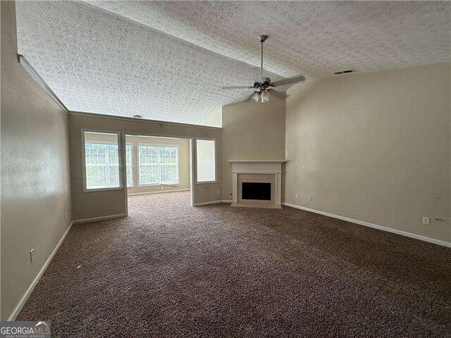 124 Sparkling Spring Trl, Mcdonough, GA 30252 - unfurnished living room featuring a ceiling fan, a textured ceiling, baseboards, a fireplace, and carpet