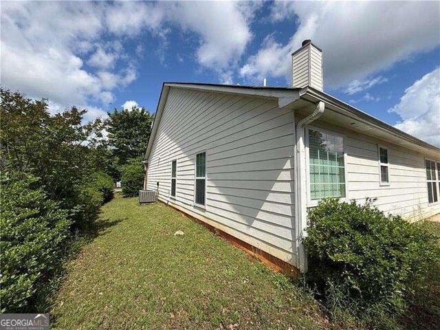 124 Sparkling Spring Trl, Mcdonough, GA 30252 - view of side of property with cooling unit, a chimney, and a lawn
