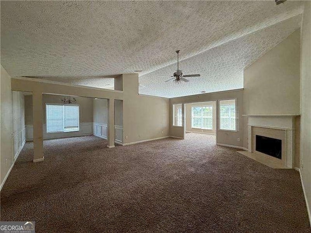 124 Sparkling Spring Trl, Mcdonough, GA 30252 - unfurnished living room with a textured ceiling, a ceiling fan, vaulted ceiling, a high end fireplace, and carpet