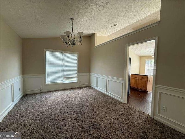 124 Sparkling Spring Trl, Mcdonough, GA 30252 - carpeted empty room with a chandelier, a decorative wall, a textured ceiling, and a wainscoted wall