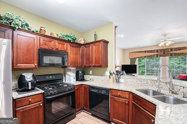 129 Finsbury Ln, Woodstock, GA 30188 - kitchen with black appliances, a sink, light wood-style flooring, ceiling fan, and light stone counters