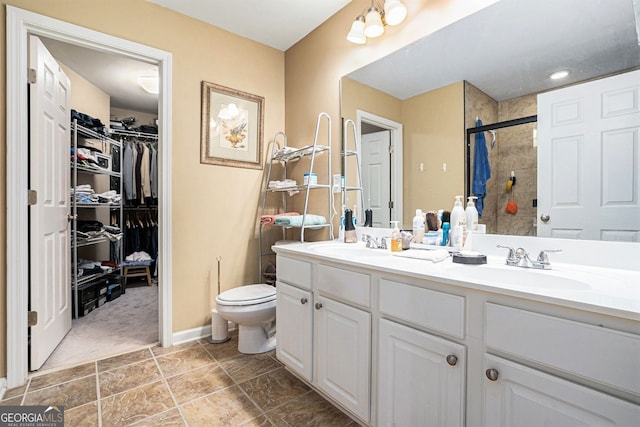 129 Finsbury Ln, Woodstock, GA 30188 - bathroom with double vanity, a stall shower, toilet, a spacious closet, and baseboards
