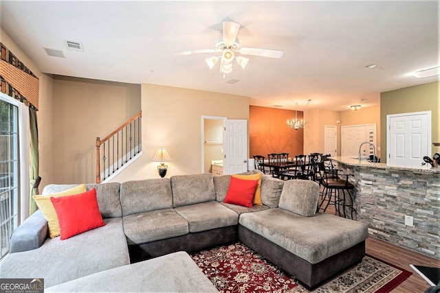 129 Finsbury Ln, Woodstock, GA 30188 - living room featuring wood finished floors, stairway, ceiling fan, and a chandelier