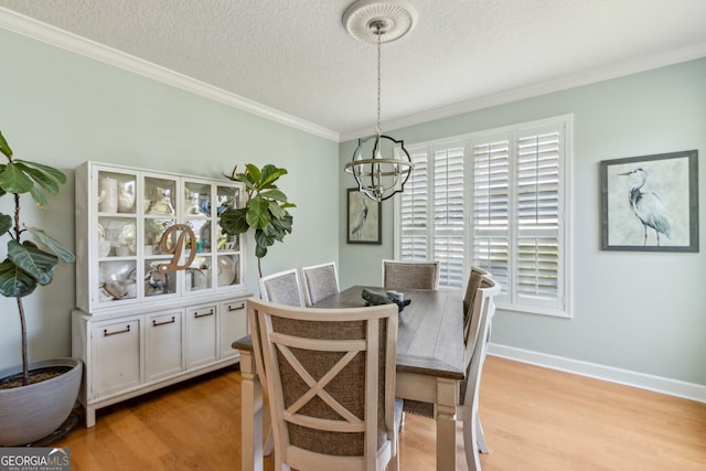 247 Laurel Landing Blvd, Kingsland, GA 31548 - dining space featuring a chandelier, light wood finished floors, ornamental molding, a textured ceiling, and baseboards