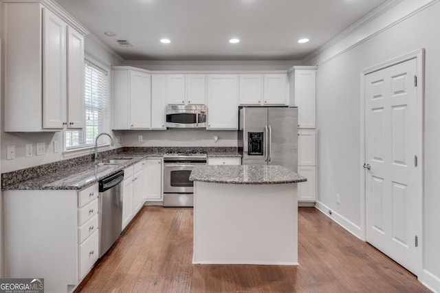 2325 Limehurst Dr NE, Atlanta, GA 30319 - kitchen with stainless steel appliances, a sink, dark stone counters, white cabinetry, and wood finished floors