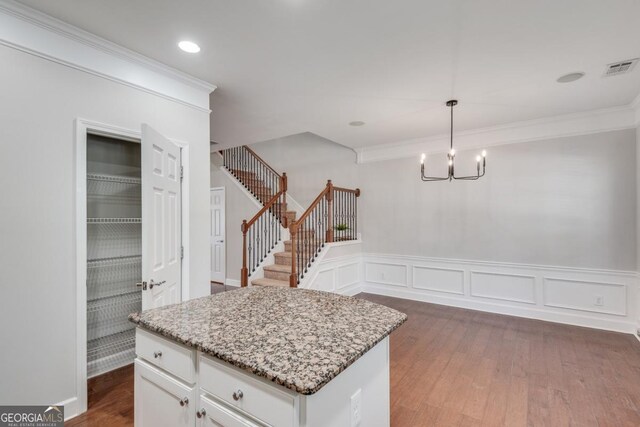2325 Limehurst Dr NE, Atlanta, GA 30319 - kitchen featuring dark wood finished floors, crown molding, light stone countertops, white cabinetry, and pendant lighting