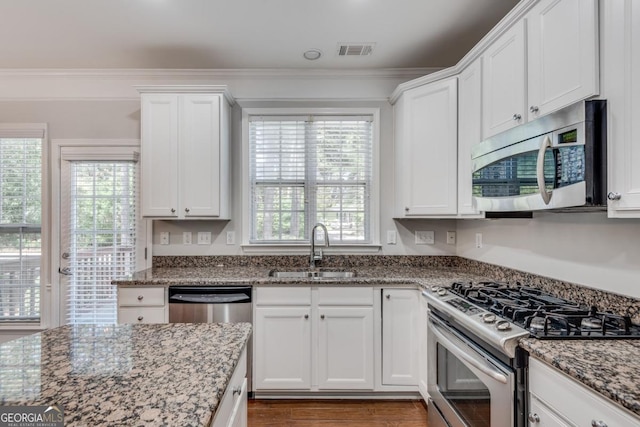 2325 Limehurst Dr NE, Atlanta, GA 30319 - kitchen with appliances with stainless steel finishes, a sink, white cabinets, stone countertops, and plenty of natural light