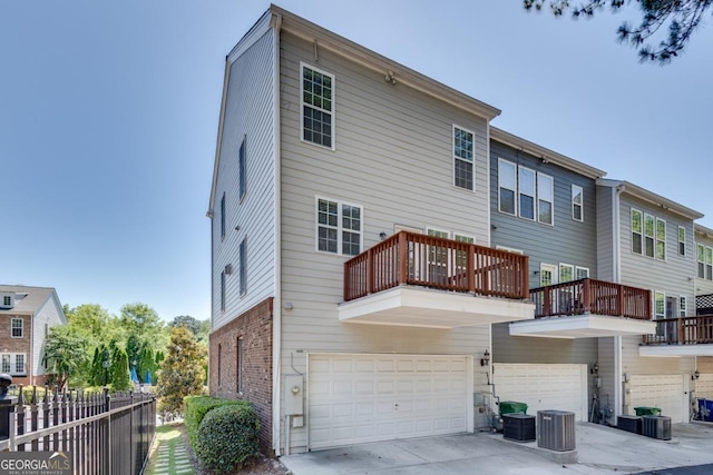 2325 Limehurst Dr NE, Atlanta, GA 30319 - rear view of property with an attached garage, a balcony, brick siding, central AC, and driveway