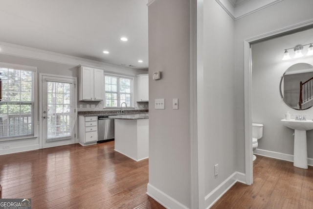 2325 Limehurst Dr NE, Atlanta, GA 30319 - kitchen with stainless steel dishwasher, white cabinets, baseboards, crown molding, and dark wood finished floors